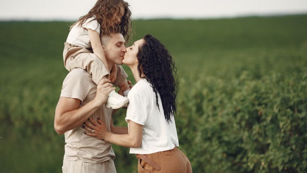 A heartwarming family moment captured in a field, highlighting love and togetherness.